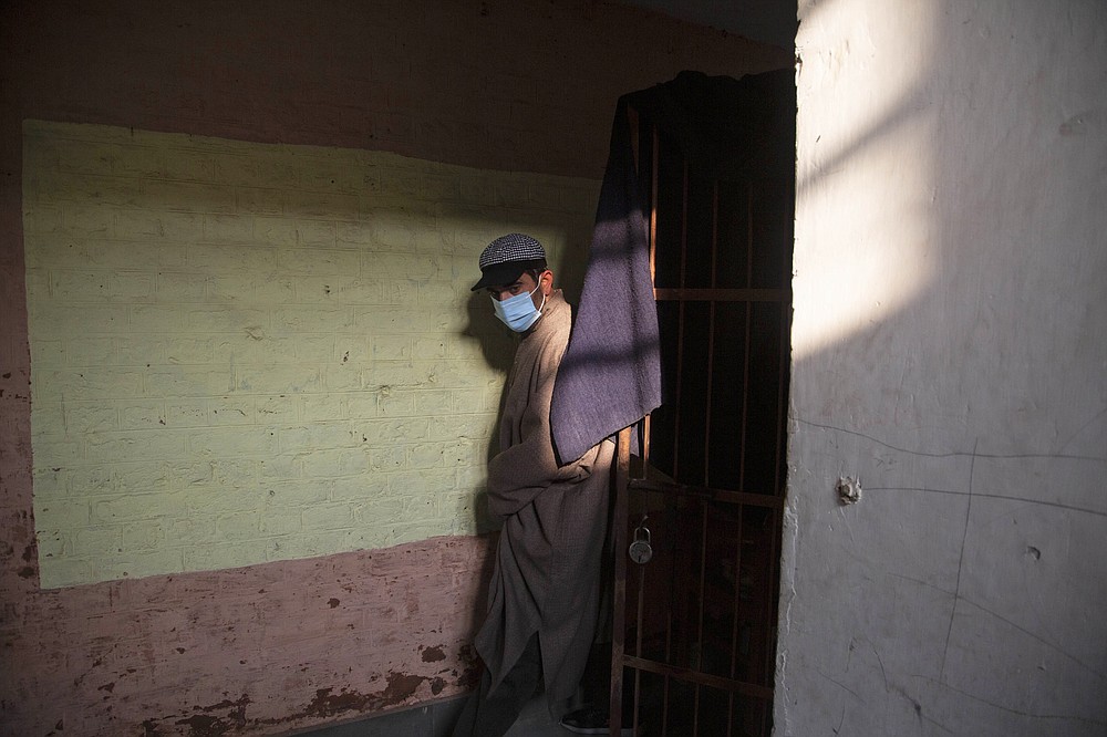 A Kashmiri arrives at a polling booth to cast his vote during the first phase of District Development Councils election on the outskirts of Srinagar, Indian controlled Kashmir, Saturday, Nov. 28, 2020. Thousands of people in Indian-controlled Kashmir voted Saturday amid tight security and freezing cold temperatures in the first phase of local elections, the first since New Delhi revoked the disputed region's semiautonomous status. (AP Photo/Mukhtar Khan)