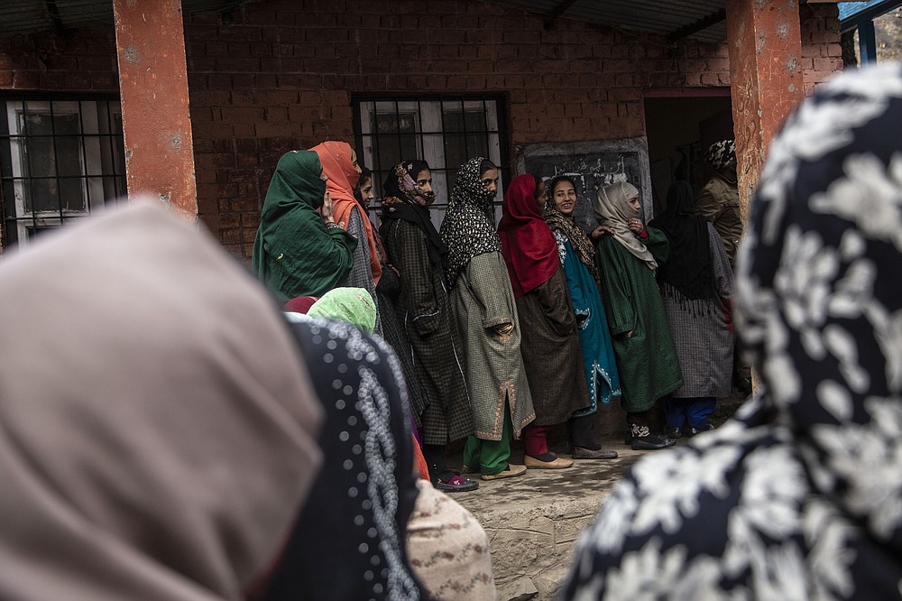 Kashmiris wait in a queue to cast their votes during the first phase of District Development Councils election on the outskirts of Srinagar, Indian controlled Kashmir, Saturday, Nov. 28, 2020. Thousands of people in Indian-controlled Kashmir voted Saturday amid tight security and freezing cold temperatures in the first phase of local elections, the first since New Delhi revoked the disputed region's semiautonomous status. (AP Photo/Mukhtar Khan)