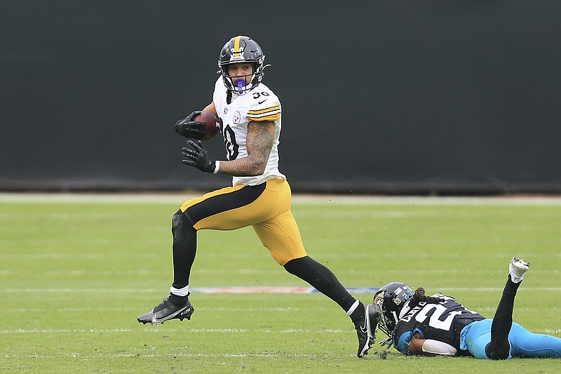 Pittsburgh Steelers running back James Conner, left, slips past Jacksonville Jaguars cornerback Chris Claybrooks for a gain during the first half of Sunday's game in Jacksonville, Fla. - Photo by Matt Stamey of The Associated Press