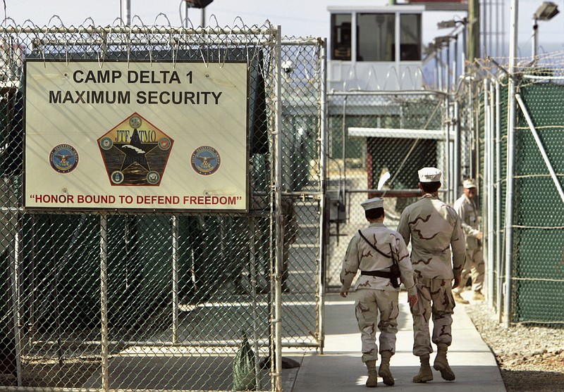 FILE - In this June 27, 2006, file photo, reviewed by a U.S. Department of Defense official, U.S. military guards walk within Camp Delta military-run prison, at the Guantanamo Bay U.S. Naval Base, Cuba. A federal judge has turned back an effort to delay an independent medical review for Saudi citizen Mohammed al-Qahtani, held at the Guantanamo Bay detention center who was so badly mistreated in American custody that he cannot be put on trial.  (AP Photo/Brennan Linsley, File)