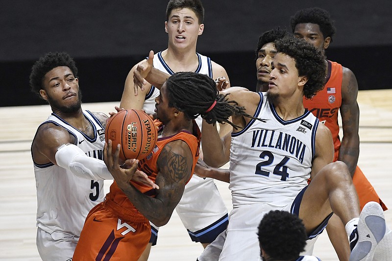 Virginia Tech's Cartier Diarra is fouled by Villanova's Justin Moore, left, as Villanova's Jeremiah Robinson-Earl, right, defends during the second half of Saturday's game in Uncasville, Conn. - Photo by Jessica Hill of The Associated Press