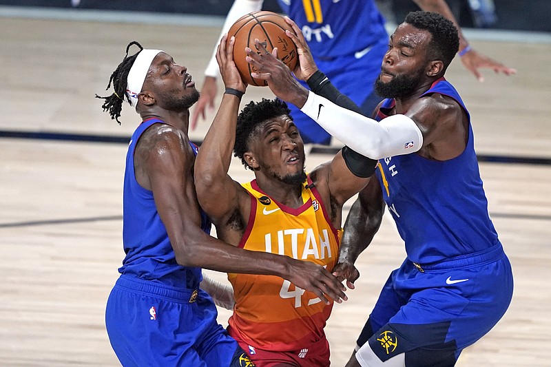 FILE - In this Aug. 30, 2020, file photo, Utah Jazz's Donovan Mitchell, center, goes up to shoot as Denver Nuggets' Jerami Grant, left, and Paul Millsap, right, defend during the second half of an Aug. 30 first round playoff game in Lake Buena Vista, Fla. - Photo by Ashley Landis of The Associated Press