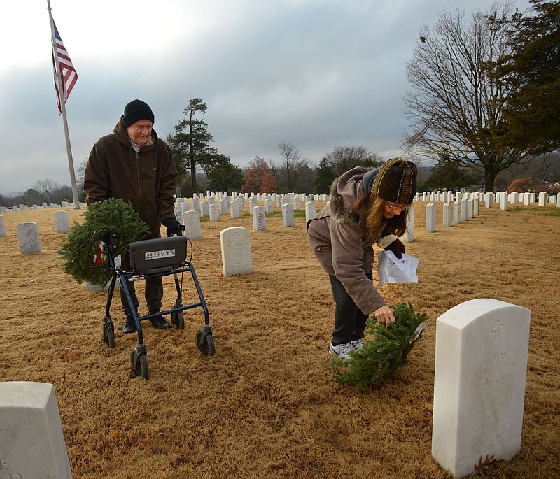 NWA Democrat-Gazette/ANDY SHUPE
Marge Guist (right) of Prairie Grove and her husband, Jim Guist, place a wreath Dec. 15, 2018 at the gravestone of Anna Turner and her husband, Jerry Turner, during the 12th annual Wreaths Across America effort at the Fayetteville National Cemetery. The annual wreath-laying effort will happen this year, but volunteers must schedule a time as the number of people in the cemetery at one time must be controlled because of the pandemic.