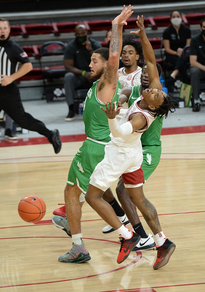 Arkansas guard JD Notae, center, collides with North Texas forwards Zachary Simmons, left, and Thomas Bell, right, during the first half of Saturday's game in Bud Walton Arena. - Photo by Andy Shupe of NWA Democrat-Gazette