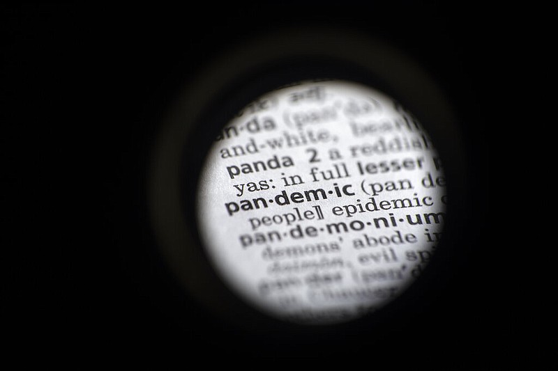 In this Saturday, Nov. 21, 2020, photo taken through a camera lens the word "pandemic" in seen in a dictionary in Washington. Dictionary.com declared “pandemic” its 2020 word of the year. (AP Photo/Jenny Kane)