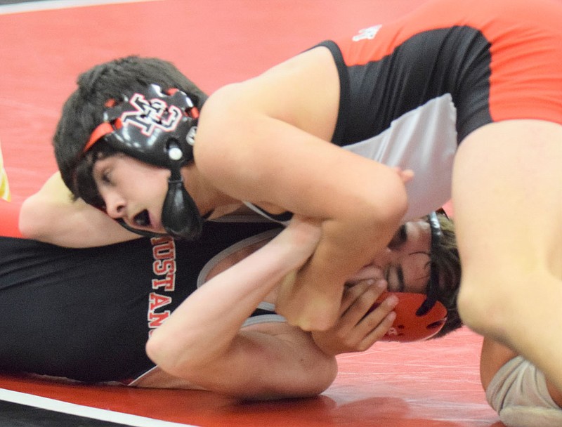 RICK PECK/SPECIAL TO MCDONALD COUNTY PRESS McDonald County sophomore Blaine Ortiz nears pinning Ayden Ball during the 11th Annual Red and Black Dual held on Nov. 24 at MCHS.