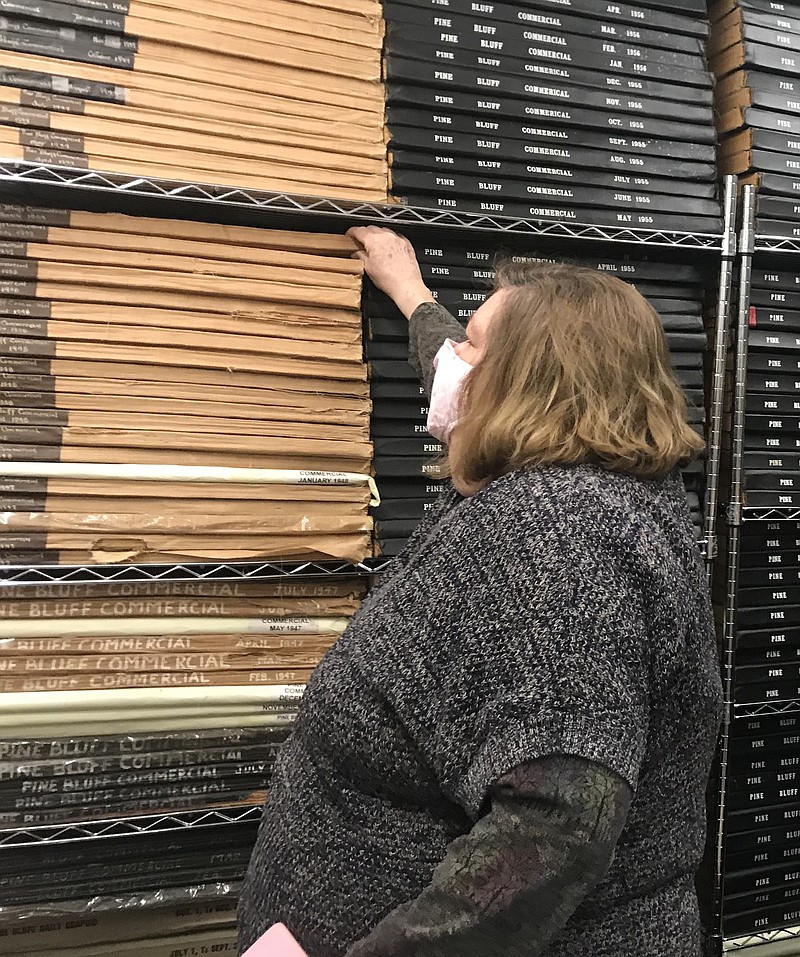 Bobbie Morgan, director of the Pine Bluff/Jefferson County Library System, looks over racks of Pine Bluff Commercial back issues the library has in its inventory going back more than 80 years. (Pine Bluff Commercial/Dale Ellis)