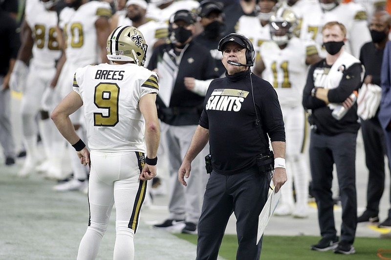 New Orleans Saints head coach Sean Payton, right, speaks with quarterback Drew Brees (9) during the first half of a Sept. 21 game against the Las Vegas Raiders in Las Vegas. The NFL has fined the New Orleans Saints $500,000 and stripped them of a 2021 seventh-round draft pick for violating league COVID-19 protocols, a person with direct knowledge of the discipline told The Associated Press on Sunday. New Orleans was fined as a repeat offender; Payton previously was docked $150,000 and the team $250,000 because the head coach failed to properly wear a face covering against the Raiders in Week 2. - Photo by Isaac Brekken of The Associated Press