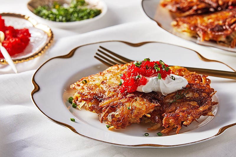 Latkes topped with sour cream, salmon roe, chives and dill (For The Washington Post/Tom McCorkle)