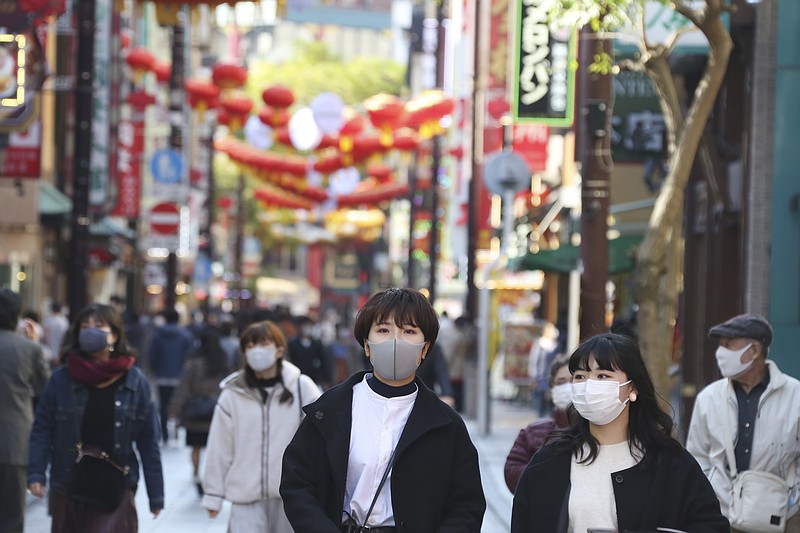 People wearing face masks to protect against the spread of the coronavirus walk through China Town in Yokohama, Kanagawa prefecture, near Tokyo, Tuesday, Dec. 1, 2020. (AP Photo/Koji Sasahara)