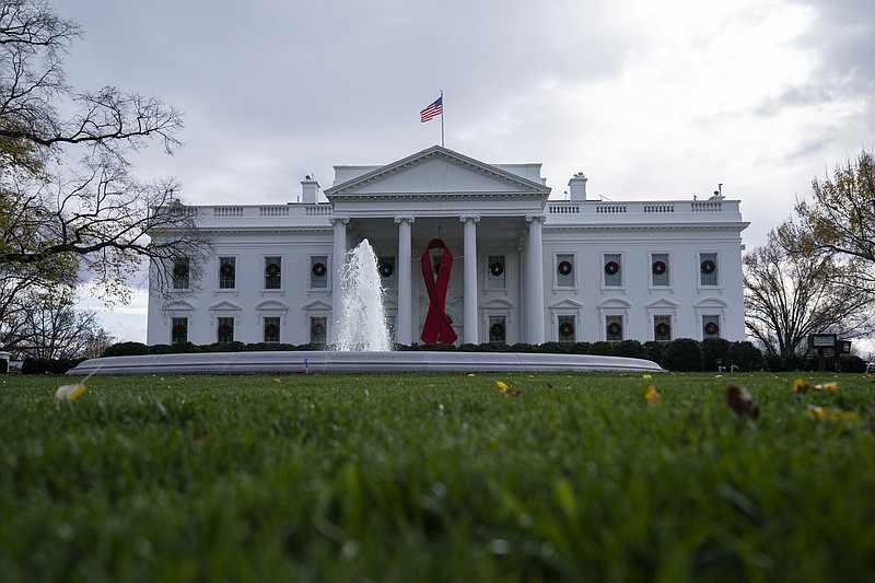 A ribbon hangs on the White House for World AIDS Day 2020, Tuesday, Dec. 1, 2020, in Washington. (AP Photo/Evan Vucci)