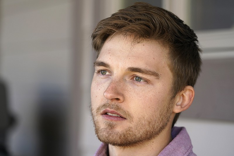 Landon Brown, a senior nursing student at Minnesota State University, Mankato, sits on the front porch of his parents' home, Tuesday, Dec. 1, 2020, in Runnells, Iowa. Brown said he hopes to be accepted to an internship at Mayo Health Systems to ease the strain on nurses during the coronavirus outbreak and give him experience as he nears graduation. “I definitely want to put my skills to use and just absorb as much as I can, and this is a perfect opportunity to do that,” he said. (AP Photo/Charlie Neibergall)