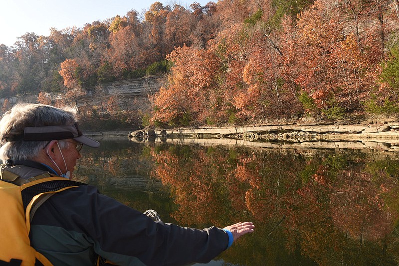 Joe Neal of Fayetteville admires the reflection of a bluff on glass-smooth water Nov. 6 2020 at Beaver Lake. Neal looked for birds near Rocky Branch park, one of the top birding destinations on the lake. Neal found raptors, waterfowl and songbirds during a morning of birding by boat. Go to nwaonline.com/201208Daily/ to see more photos.
(NWA Democrat-Gazette/Flip Putthoff