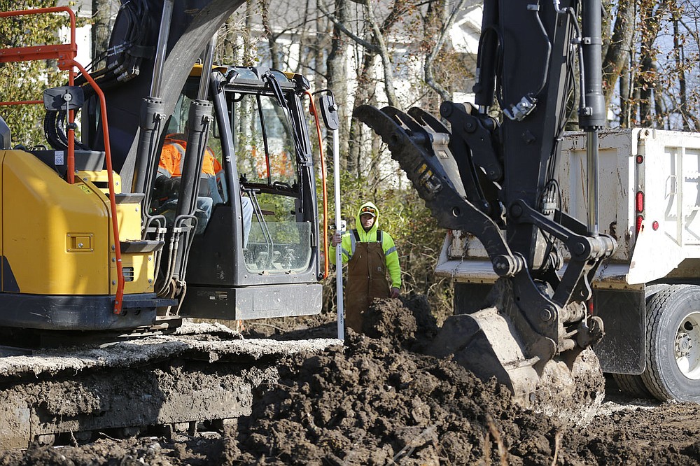 Joshua Littrell, with the city of Fayetteville Trails Department, monitors Friday, Dec. 4, 2020, work on the Clabber Creek Trail between Truckers Drive and Holcomb Elementary School in Fayetteville. The city has about 5 miles of new trail construction planned next year using a mix of capital, bond and grant money. Check out nwaonline.com/201206Daily/ and nwadg.com/photos for a photo gallery.
(NWA Democrat-Gazette/David Gottschalk)