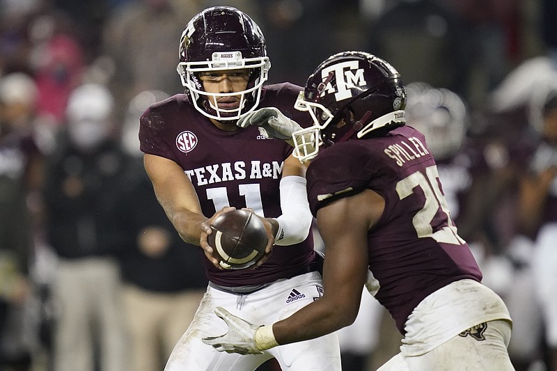 Texas A&M quarterback Kellen Mond (11) hands the ball off to running back Isaiah Spiller (28) during the fourth quarter of an NCAA college football game against LSU, Saturday, Nov. 28, 2020, in College Station, Texas. (AP Photo/Sam Craft)
