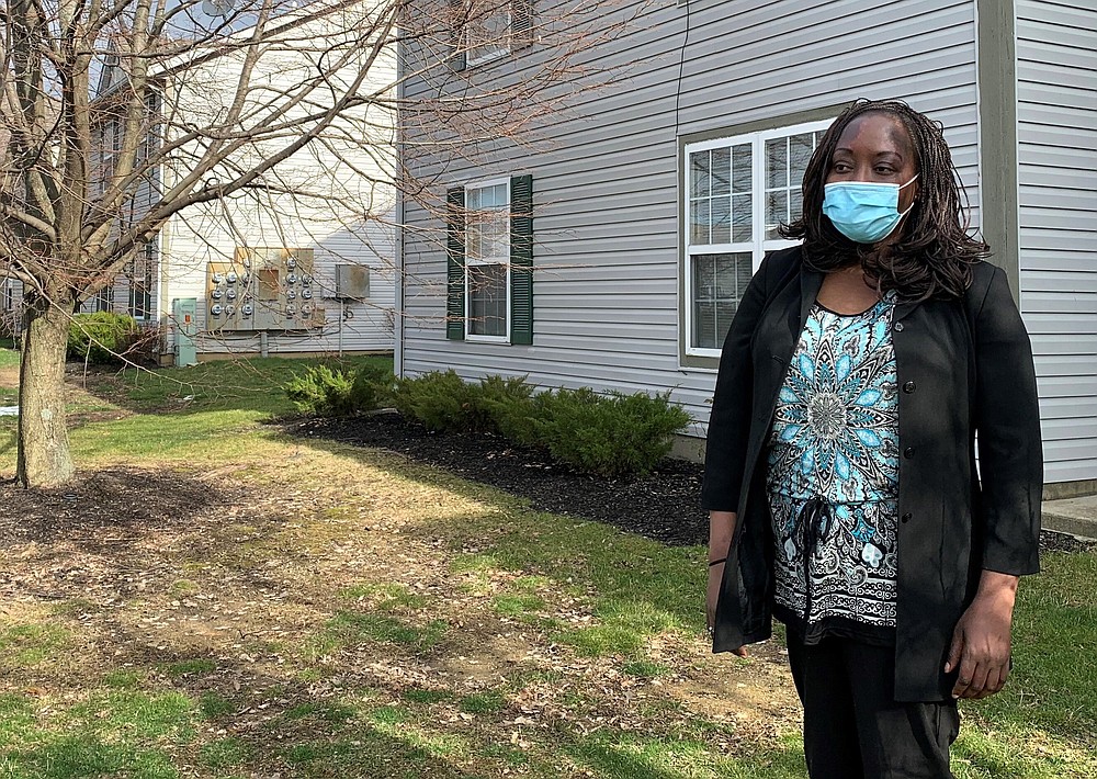 Agnes Makokha, 45, of Columbus, Ohio, stands outside her apartment Friday, December 4, 2020. Makokha is among millions of Americans at risk of losing unemployment benefits come Dec. 26.  She lost her job in December and due to hiring freezes in place since the pandemic began, has been unable to find employment.  (AP Photo/Farnoush Amiri)