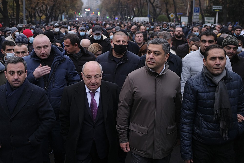 Opposition leaders, from left in the first row, Ishkhan Saghatelyan, Vazgen Manukyan, Artur Vanetsyan and Arman Abovyan lead a rally to pressure Armenian Prime Minister Nikol Pashinyan to resign over a peace deal with neighboring Azerbaijan in Republic Square in Yerevan, Armenia, Saturday, Dec. 5, 2020. Tens of thousands of opposition supporters marched across the Armenian capital Saturday to push for the resignation of the ex-Soviet nation's prime minister over his handling of the conflict with Azerbaijan over Nagorno-Karabakh. (Hrant Khachatryan /PAN Photo via AP)