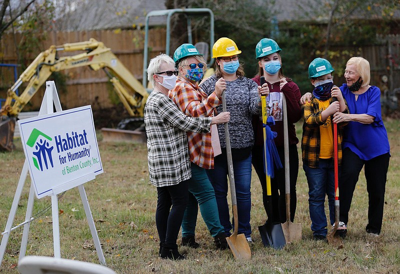 Neaomie Ryan (from right) hugs Lyric Cote, 10, as he stands with his sister Zoe Griffis, mother Angela Sockrider, Sockrider’s mother Diana Holmes and aunt Linda Look Monday, November 9, 2020, during a Habitat for Humanity of Benton County ground breaking event for a new home for Sockrider at 808 N. 31st Street in Rogers. Check out nwaonline.com/201126Daily/ and nwadg.com/photos for a photo gallery.(NWA Democrat-Gazette/David Gottschalk)