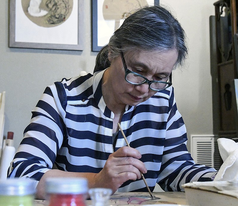 Shunying Chen works on a painting inside her home on June 19, 2019. - Photo by Grace Brown of The Sentinel-Record