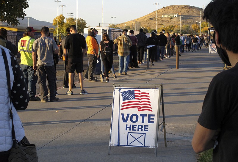 In this Nov. 3 file photo, mostly masked northern Nevadans wait to vote in-person at Reed High School in Sparks, Nev., prior to polls closing. The acrimonious 2020 presidential election is spotlighting an effort to get rid of the current Electoral College system and instead elect America's leader by a national popular vote. Advocates hope it'll be in place by the next presidential election. - AP Photo/Scott Sonner