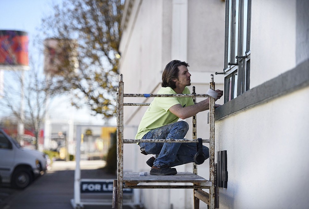 Jon Athon cleans a window of the Harris Bakery building, Thursday, December 10, 2020 near the alleyway between First and Second Streets from Elm to Chestnut Streets in downtown Rogers. These alleyways will be part of an upcoming alleyway revitalization project that will be part of the city's cultural plan. The idea is to relocate dumpsters and resurface the alleyway, add lighting and amenities with artwork so that the alleyways become a comfortable place for pedestrians. Check out nwaonline.com/201211Daily/ for today's photo gallery.
(NWA Democrat-Gazette/Charlie Kaijo)