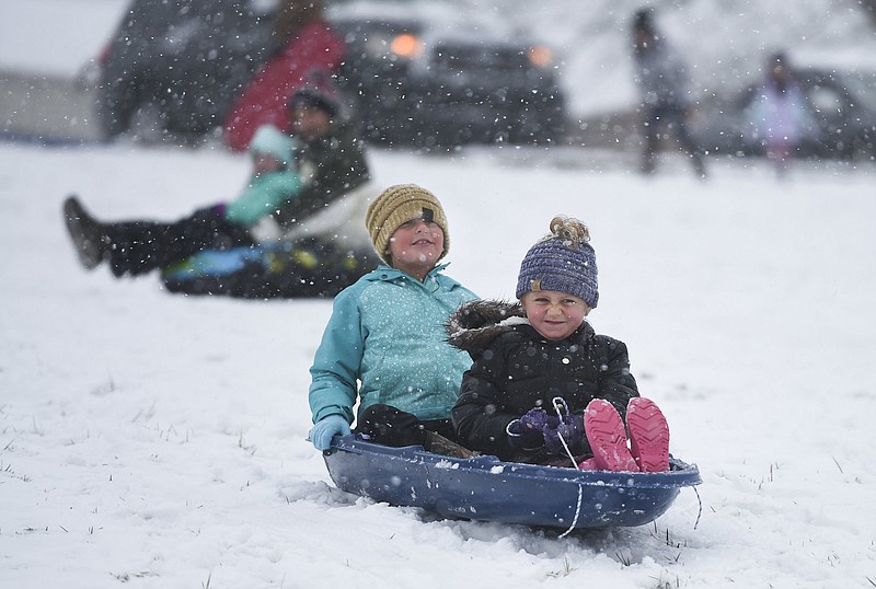 Shiloh Whiteeagle, 7, (from left) and Stella Lewis, 6, of Bentonville sled, Sunday, December 13, 2020 down a steep hill at Bethel Baptist Church in Bentonville. Check out nwaonline.com/201214Daily/ for today's photo gallery. 
(NWA Democrat-Gazette/Charlie Kaijo)