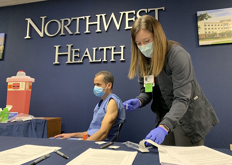 Kelly Tanakatsubo (right), a nurse with Northwest Health in Springdale, prepares to administer a covid-19 vaccine Tuesday to Dr. Burton Bledsoe, chief of staff, at the medical center in Springdale. Frontline medical staff began receiving the vaccine. Visit nwaonline.com/201216Daily/ for today's photo gallery. 
(NWA Democrat-Gazette/Andy Shupe)