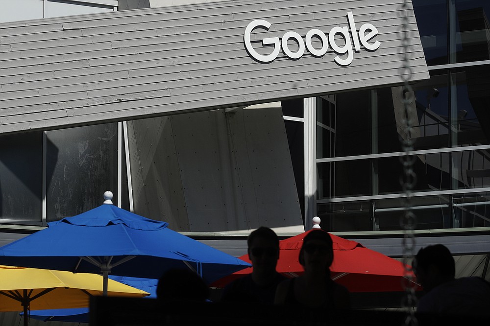 In this Sept. 24, 2019, file photo people walk by a Google sign on the company's campus in Mountain View, Calif. A group of 35 states as well as the District of Columbia and the territories of Guam and Puerto Rico filed an anti-trust lawsuit against Google on Thursday, Dec. 17, 2020, alleging that the search giant has an illegal monopoly over the online search market that hurts consumers and advertisers. The lawsuit, announced by Colorado Attorney General Phil Weiser, was filed in federal court in Washington, D.C. by states represented by bipartisan attorneys general. (AP Photo/Jeff Chiu, File)