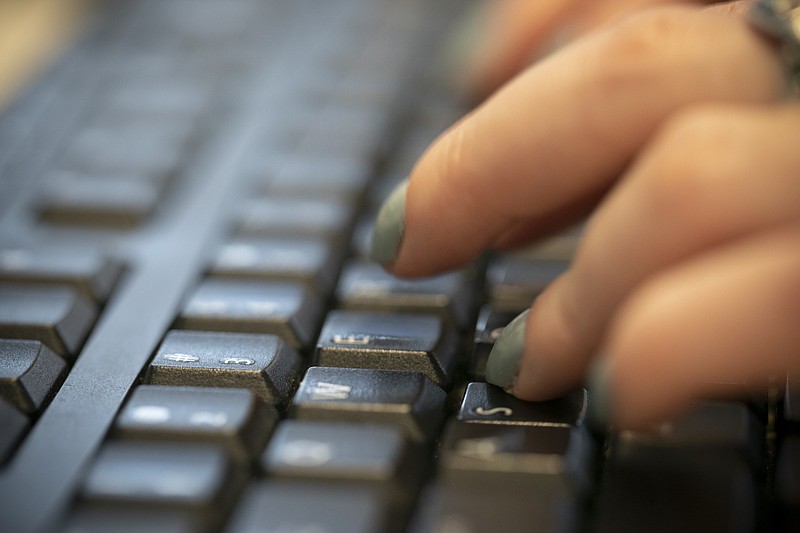 FILE - In this Tuesday, Oct. 8, 2019, file photo, a woman types on a keyboard in New York. (AP Photo/Jenny Kane, File)