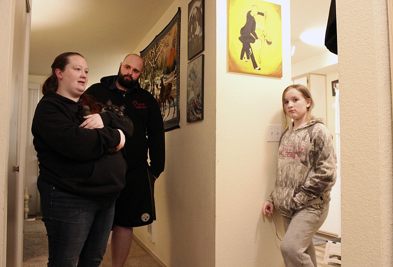 Taylor Wood and her boyfriend, Ryan Bowser, talk to Wood's 10-year-old daughter, Freya Wood, in their Corvallis, Ore., apartment on Dec. 11, 2020. The family, who has been living in the apartment for over two years, has missed three rent payments during the pandemic. (AP Photo/Sara Cline)