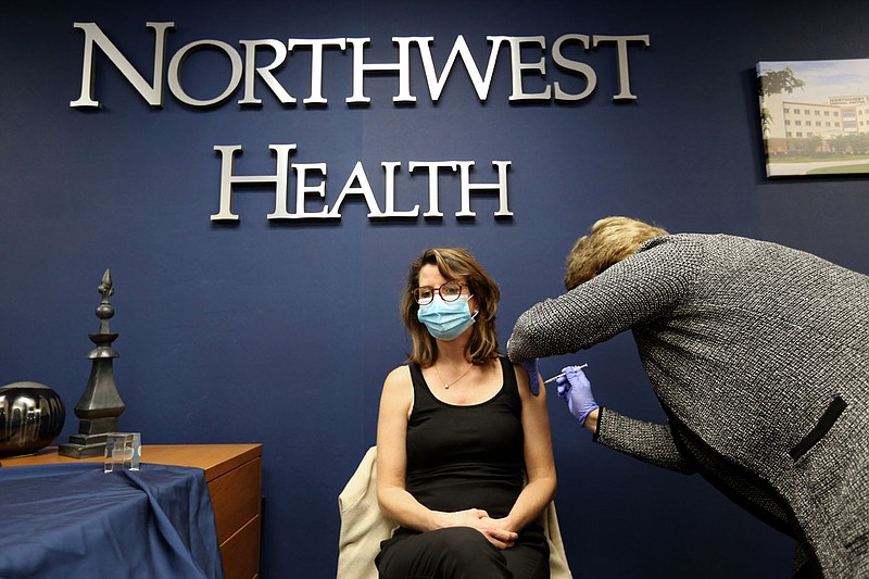 Susan Kristiniak, assistant chief nursing officer at Northwest Health in Springdale, administers a covid-19 vaccine Friday, Dec. 18, 2020, to Dr. Marti Sharkey, city of Fayetteville public health officer, at the medical center in Springdale. Check out nwaonline.com/201219Daily/ and nwadg.com/photos for a photo gallery.
(NWA Democrat-Gazette/David Gottschalk)