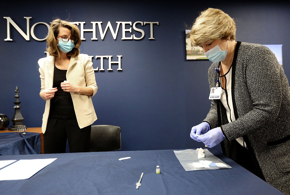 Susan Kristiniak (right), assistant chief nursing officer at Northwest Health in Springdale, prepares to administer a covid-19 vaccine Friday, Dec. 18, 2020, to Dr. Marti Sharkey, city of Fayetteville public health officer, at the medical center in Springdale. Check out nwaonline.com/201219Daily/ and nwadg.com/photos for a photo gallery.
(NWA Democrat-Gazette/David Gottschalk)