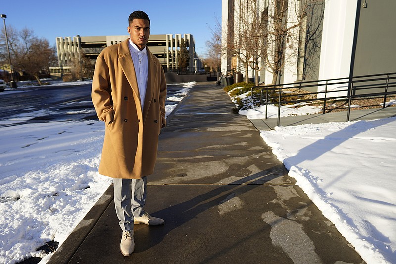 Donte Westmoreland poses for a photo outside a hotel Tuesday, Dec. 15, 2020, in southeast Denver. Westmoreland was recently released from Lansing Correctional Facility in Kansas, where he caught the virus while serving time on a marijuana charge. Some 5,000 prisoners have become infected in Kansas prisons, the second-highest COVID-19 rate in the country, second only to South Dakota. (AP Photo/David Zalubowski)