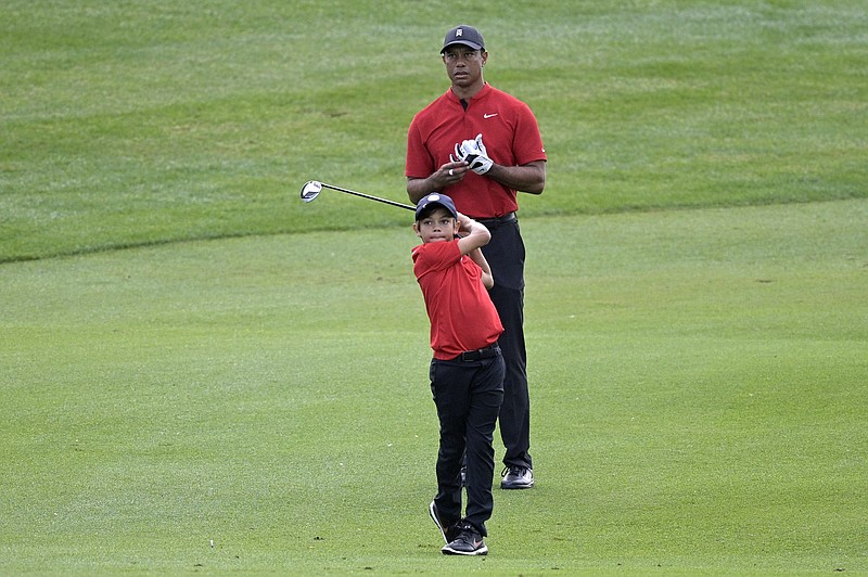 Tiger Woods watches his son Charlie's shot from the third fairway during the final round of the PNC Championship golf tournament, Sunday, Dec. 20, 2020, in Orlando, Fla. (AP Photo/Phelan M. Ebenhack)