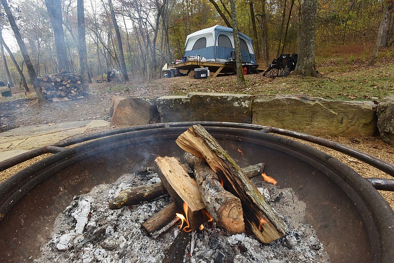 COLER WELCOMES CAMPERS
Flames flicker in the community fire ring in the campground at Coler Mountain Bike Preserve in Bentonville. New campsites at the preserve opened for camping this weekend, with most occupied on Saturday. Sites range from small and large tent platforms to sites for camper vans. Fees are $15 per night for small tent platforms, $25 for a large platform and $30 for camper van sites. Advance reservations are required and accepted online at www.peelcompton.org. The mountain bike preserve is in northwest Bentonville and features miles of mountain bike trails, a hard-surface trail and the campground. There is no cost to ride the trails. Go to nwaonline.com/201025Daily/ to see more photos.
(NWA Democrat-Gazette/Flip Putthoff)