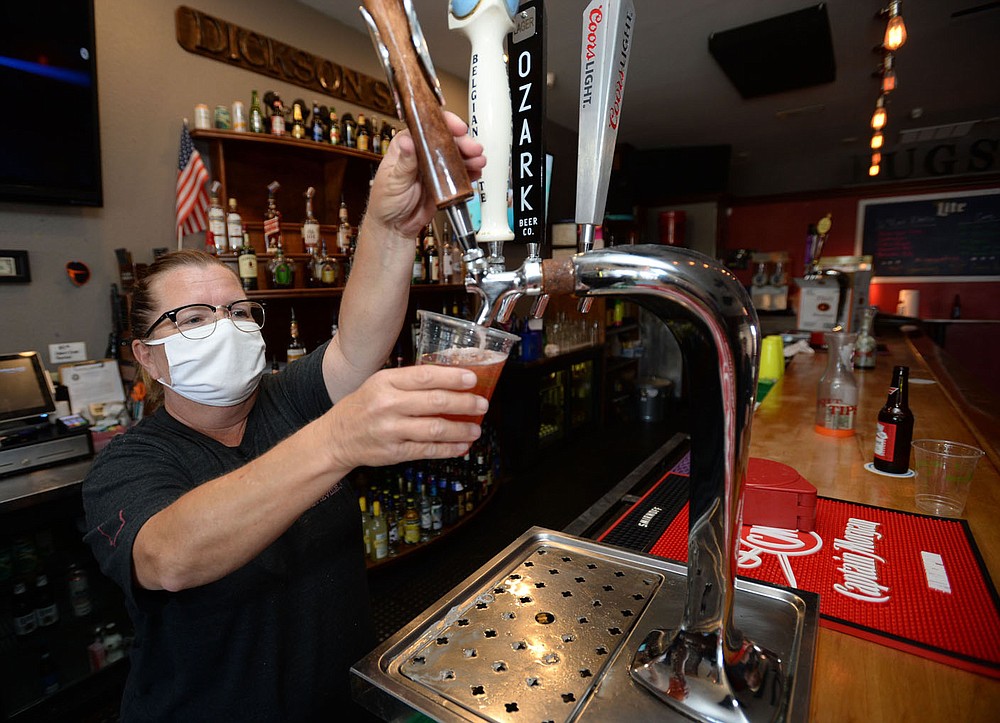 Melissa Broyles-Langley, a bartender at Bugsy's on Dickson Street, pours a draft beer Thursday, Aug. 20, 2020, into a to-go cup at the bar in Fayetteville. The city‚Äôs outdoor refreshment area opened downtown July 22, allowing customers of certain establishments to take drinks outside on designated streets. Visit nwaonline.com/200823Daily/ for today's photo gallery.
(NWA Democrat-Gazette/Andy Shupe)