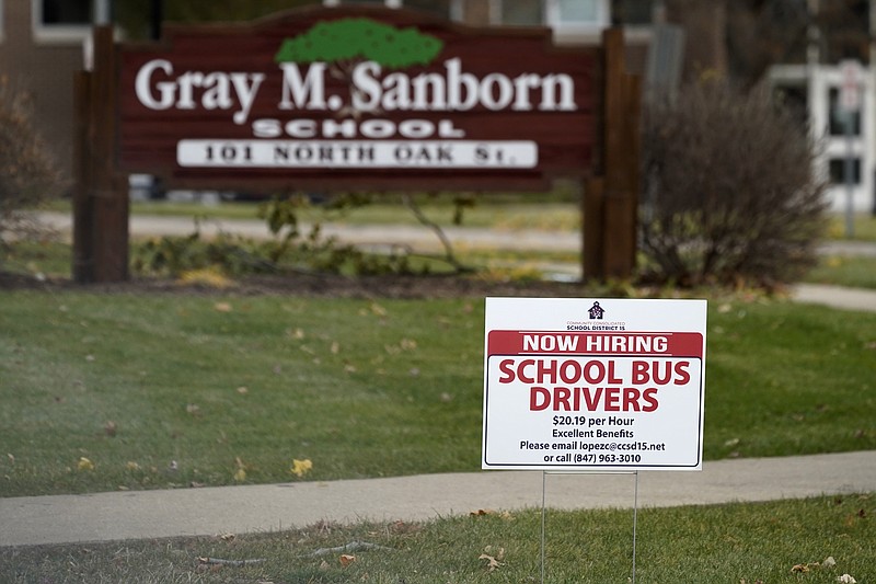 A hiring sign shows outside of Gray M. Sanborn Elementary School in Palatine, Ill., Thursday, Nov. 5, 2020. Illinois reports biggest spike in unemployment claims of all states. On Wednesday, Dec. 23, the number of Americans seeking unemployment benefits fell by 89,000 last week to a still-elevated 803,000, evidence that the job market remains under stress nine months after the coronavirus outbreak sent the U.S. economy into recession and caused millions of layoffs.  (AP Photo/Nam Y. Huh)