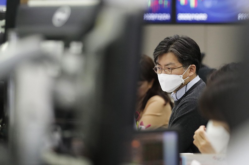 A currency trader watches computer monitors at the foreign exchange dealing room in Seoul, South Korea, Thursday, Dec. 24, 2020. Asian shares are mostly higher after stocks eked out small gains on Wall Street following a mixed set of reports on the economy. (AP Photo/Lee Jin-man)