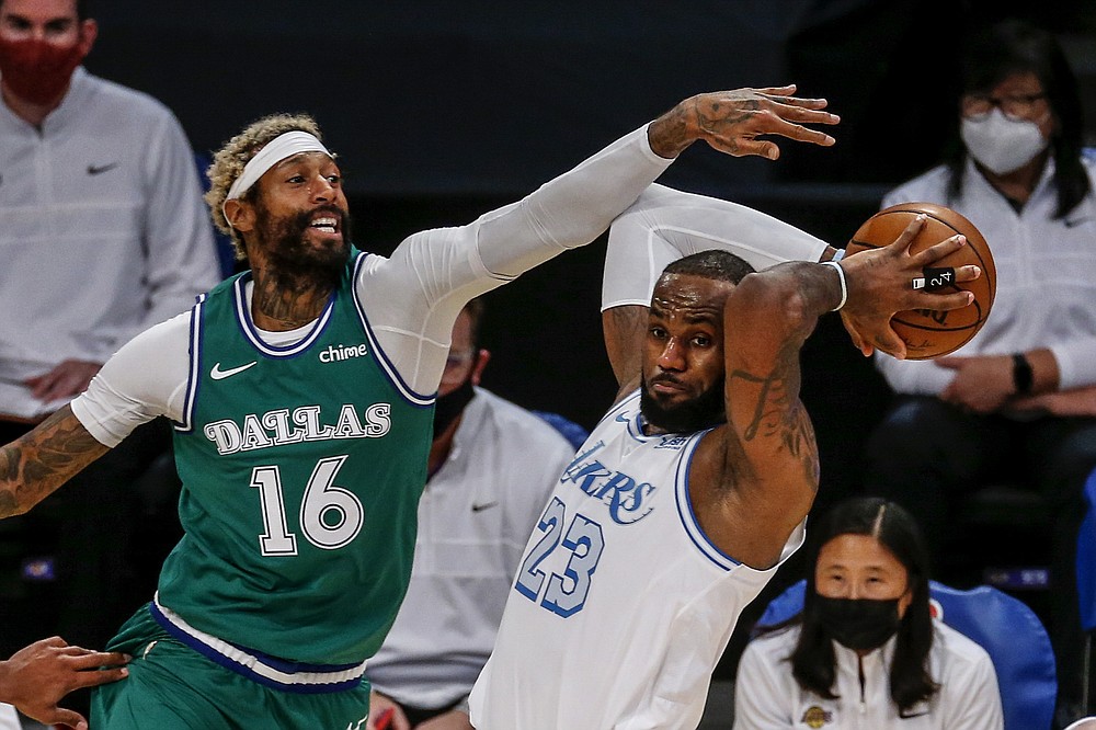 Los Angeles Lakers' LeBron James (23) looks to pass while under pressure from Dallas Mavericks' James Johnson (16) during the first half of an NBA basketball game Friday, Dec. 25, 2020, in Los Angeles. (AP Photo/Ringo H.W. Chiu)