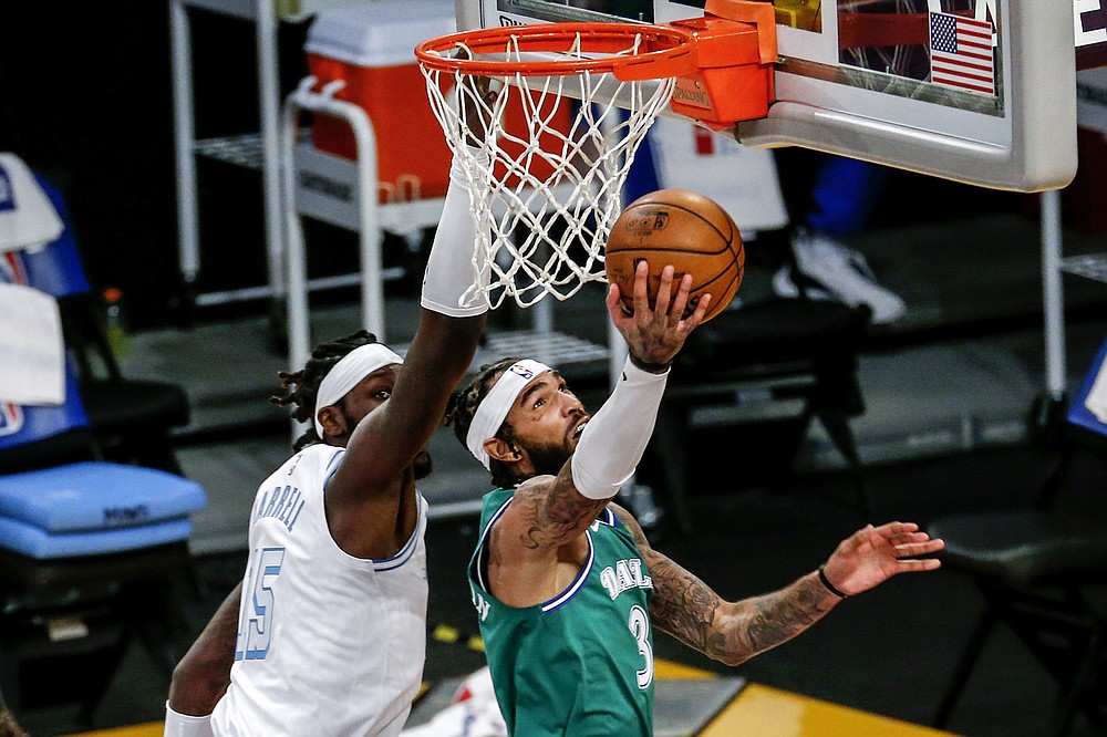 Dallas Mavericks' Willie Cauley-Stein (33) goes to the basket while defended by Los Angeles Lakers' Montrezl Harrell (15) during the first half of an NBA basketball game Friday, Dec. 25, 2020, in Los Angeles. (AP Photo/Ringo H.W. Chiu)