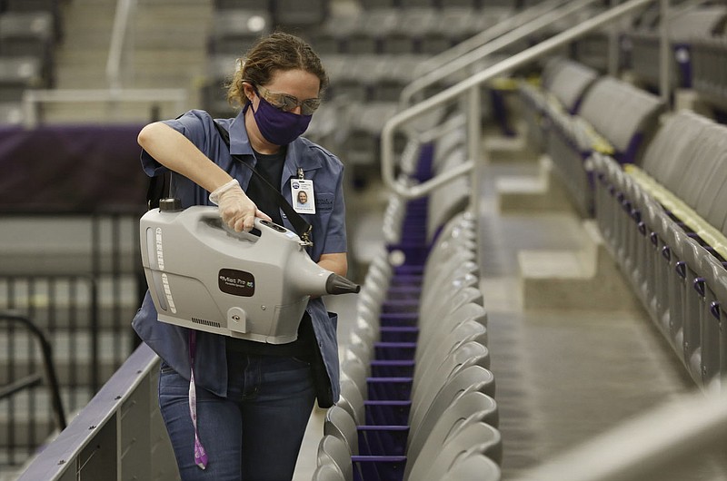 Hannah Huckabee, a custodian with Fayetteville Public Schools, uses a hospital-grade mister Dec. 15 to disinfect the bleachers in Bulldog Arena at Fayetteville High School. The cleaning procedure takes place after hours when no students are in the area. Check out nwaonline.com/201228Daily/ and nwadg.com/photos for a photo gallery.
(NWA Democrat-Gazette/David Gottschalk)