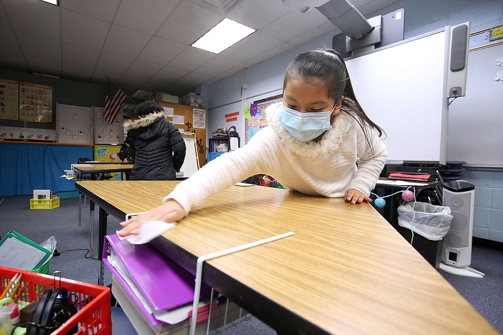 Third-grader Mary Juarez wipes down her desk with an antibacterial wipe Dec. 11 at David O. Dodd Elementary in Little Rock.
Check out nwaonline.com/201228Daily/ and nwadg.com/photos for a photo gallery.
(Arkansas Democrat-Gazette/Thomas Metthe)