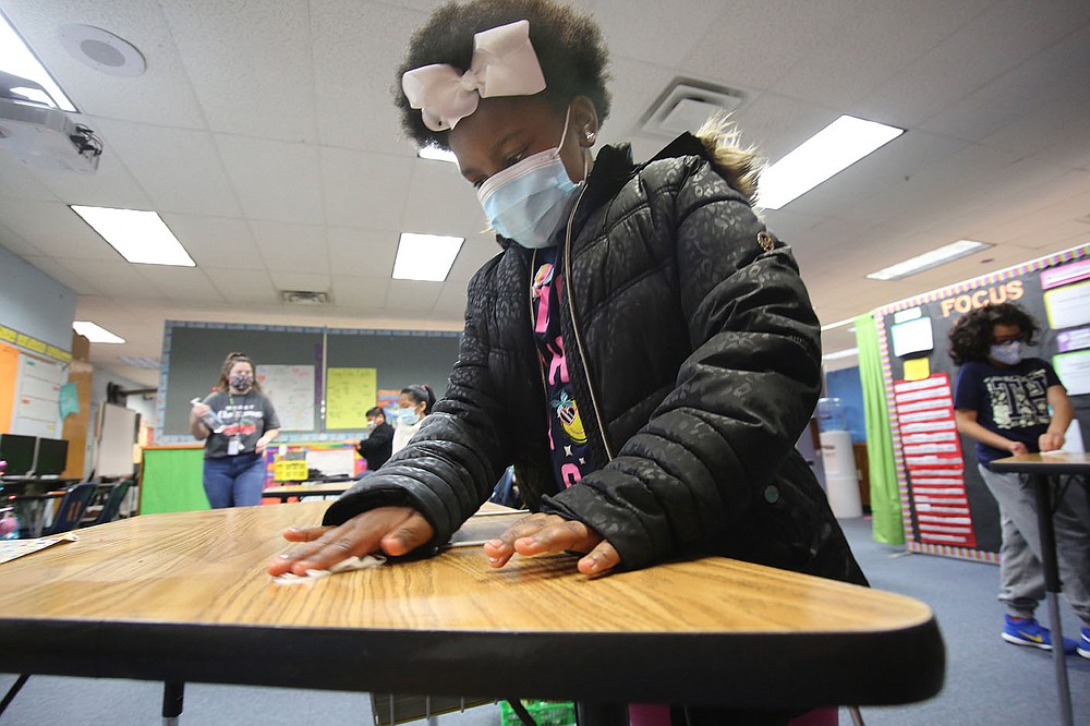 Third-grader Deaerial Hill wipes her desk down with an antibacterial wipe Dec. 11 at David O. Dodd Elementary in Little Rock.
Check out nwaonline.com/201228Daily/ and nwadg.com/photos for a photo gallery.
(Arkansas Democrat-Gazette/Thomas Metthe)