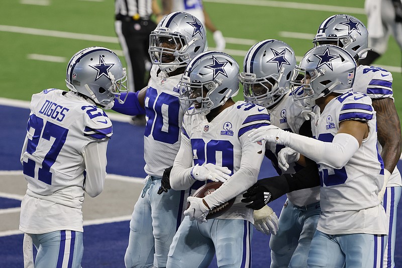 Dallas Cowboys' Trevon Diggs (27), DeMarcus Lawrence (90) and others celebrate with Anthony Brown (30), after Brown intercepted a Philadelphia Eagles quarterback Jalen Hurts pass in the end zone late in the second half of an NFL football game in Arlington, Texas, Sunday, Dec. 27. 2020. (AP Photo/Michael Ainsworth)