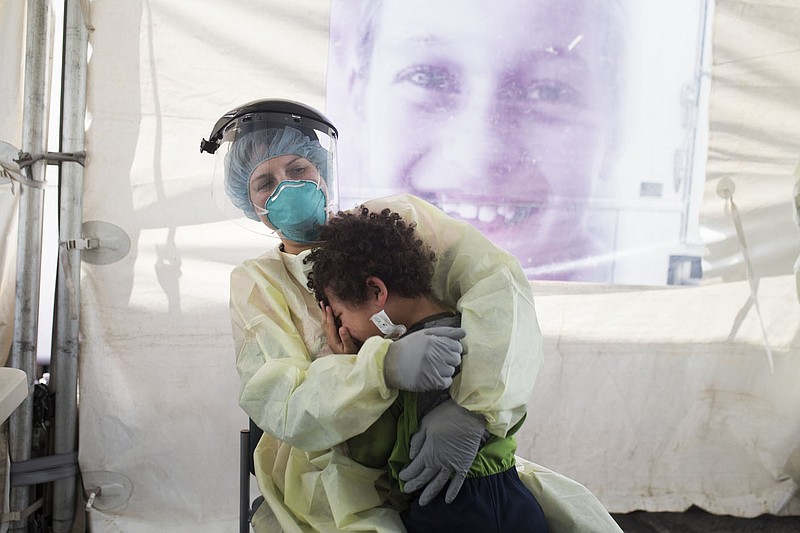 Nurse Julie Palmer consoles Luca'Brasi Means, 4, after swabbing his nose to test for covid-19, Friday, April 24, 2020 at a drive-thru testing site at the Mercy Convenient Care in Bentonville. 
(NWA Democrat-Gazette/Charlie Kaijo)