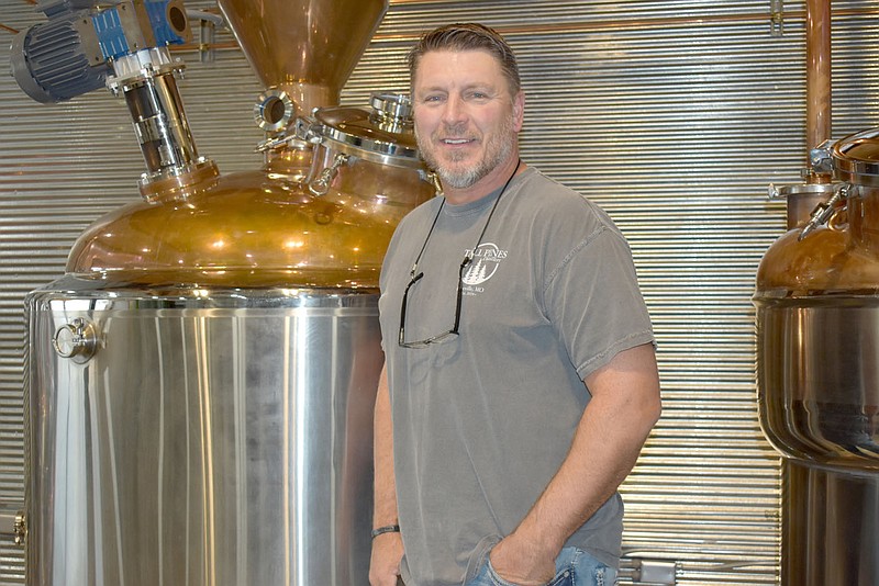 RACHEL DICKERSON/MCDONALD COUNTY PRESS Joe Cook of Tall Pines Distillery near Pineville is pictured with the still. He owns the business with wife, Tara. The distillery opened in early 2020. The owners are hoping for growth in the new year.