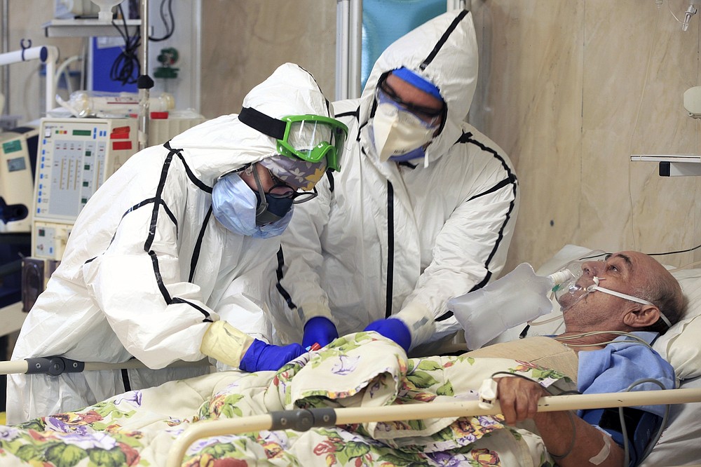 FILE - In this Oct. 14, 2020, photo provided by the Iranian Health Ministry, medics tend to a COVID-19 patient at a hospital in Tehran, Iran. Iranian media reported on Monday, Dec. 28 that an unidentified group of U.S.-based philanthropists plans to send 150,000 doses of the Pfizer vaccine to Iran in the coming weeks, in a step that could bring the hardest-hit country in the Middle East closer to inoculating its citizens against the coronavirus. (Akbar Badrkhani/Iranian Health Ministry via AP, File)
