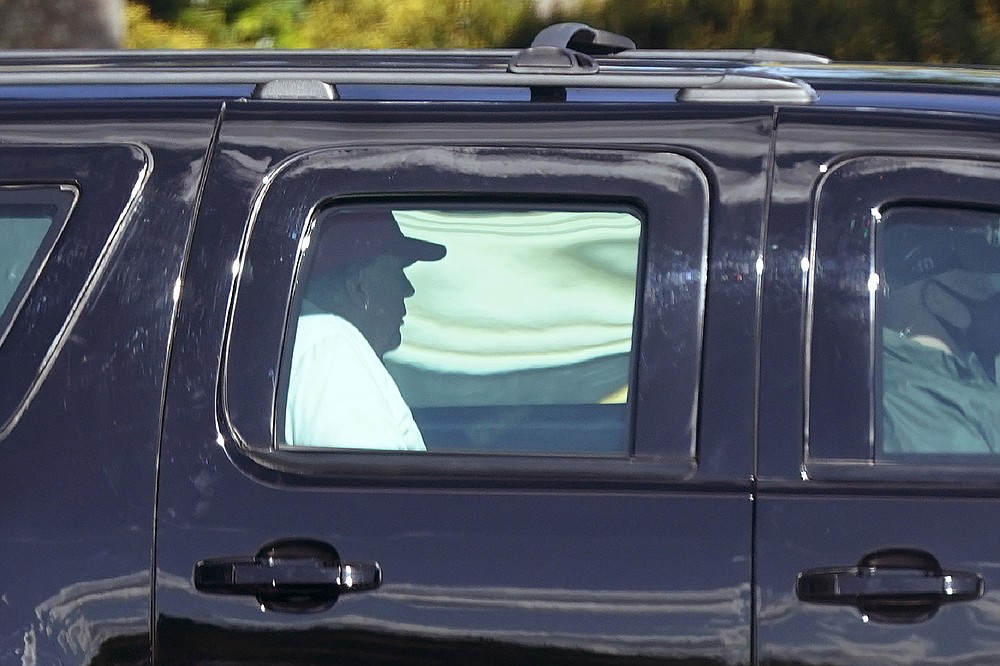 President Donald Trump rides in a motorcade vehicle as he departs Trump International Golf Club, Sunday, Dec. 27, 2020, in West Palm Beach, Fla. (AP Photo/Patrick Semansky)