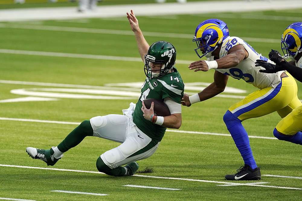 New York Jets quarterback Sam Darnold, left, slides in front of Los Angeles Rams linebacker Justin Hollins during the first half of an NFL football game Sunday, Dec. 20, 2020, in Inglewood, Calif. (AP Photo/Ashley Landis)