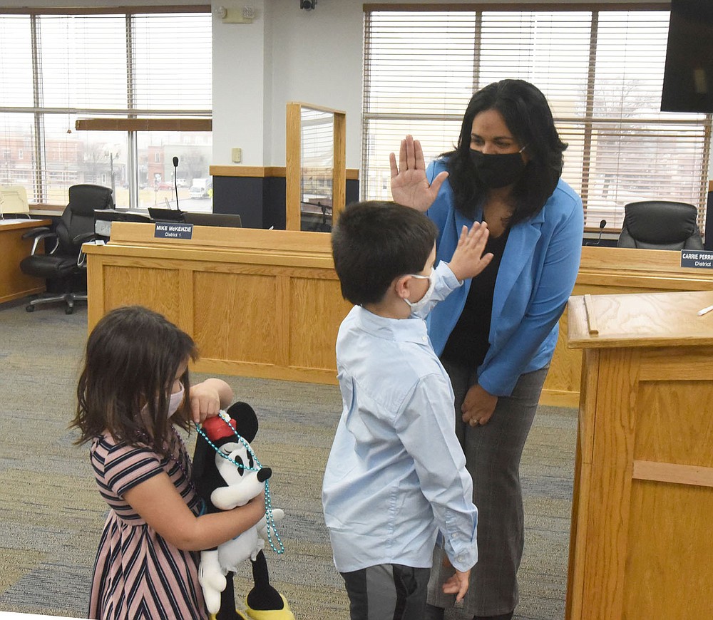 Gayatri Agnew gets a high five from her son, Rohan, 6, on Friday Jan. 1, 2021, New Year's Day, after Agnew was sworn in as a member of the Bentonville City Council. Agnew's daughter, Kamala (left), 4, also stood with her mom during the ceremony. Benton County Clerk Betsy Harrell swore in Bentonville council members at the county administration building.
(NWA Democrat-Gazette/Flip Putthoff)